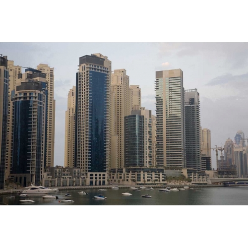 UAE, Dubai Modern buildings tower over boats